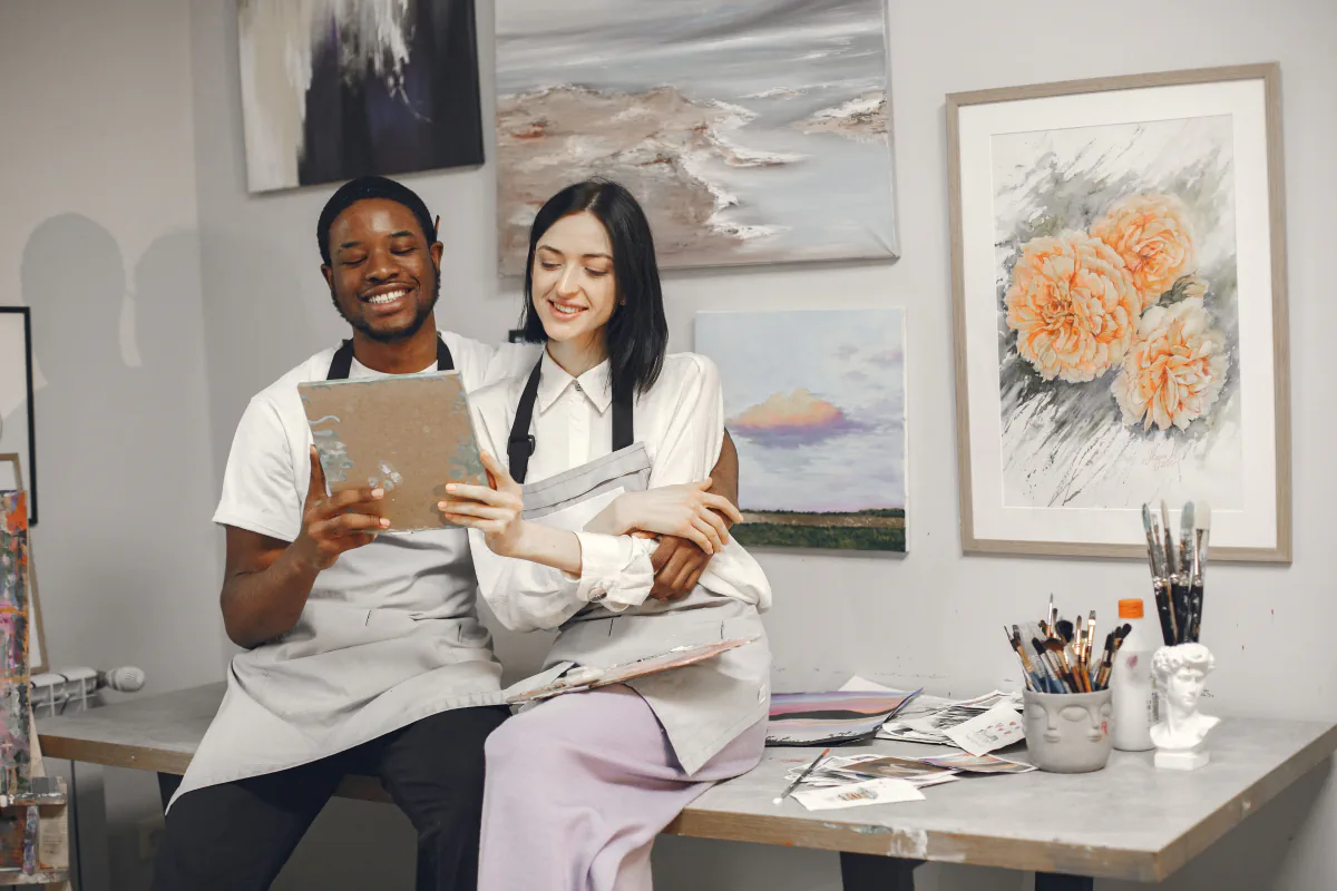 Two artists looking at a painting together in their studio.